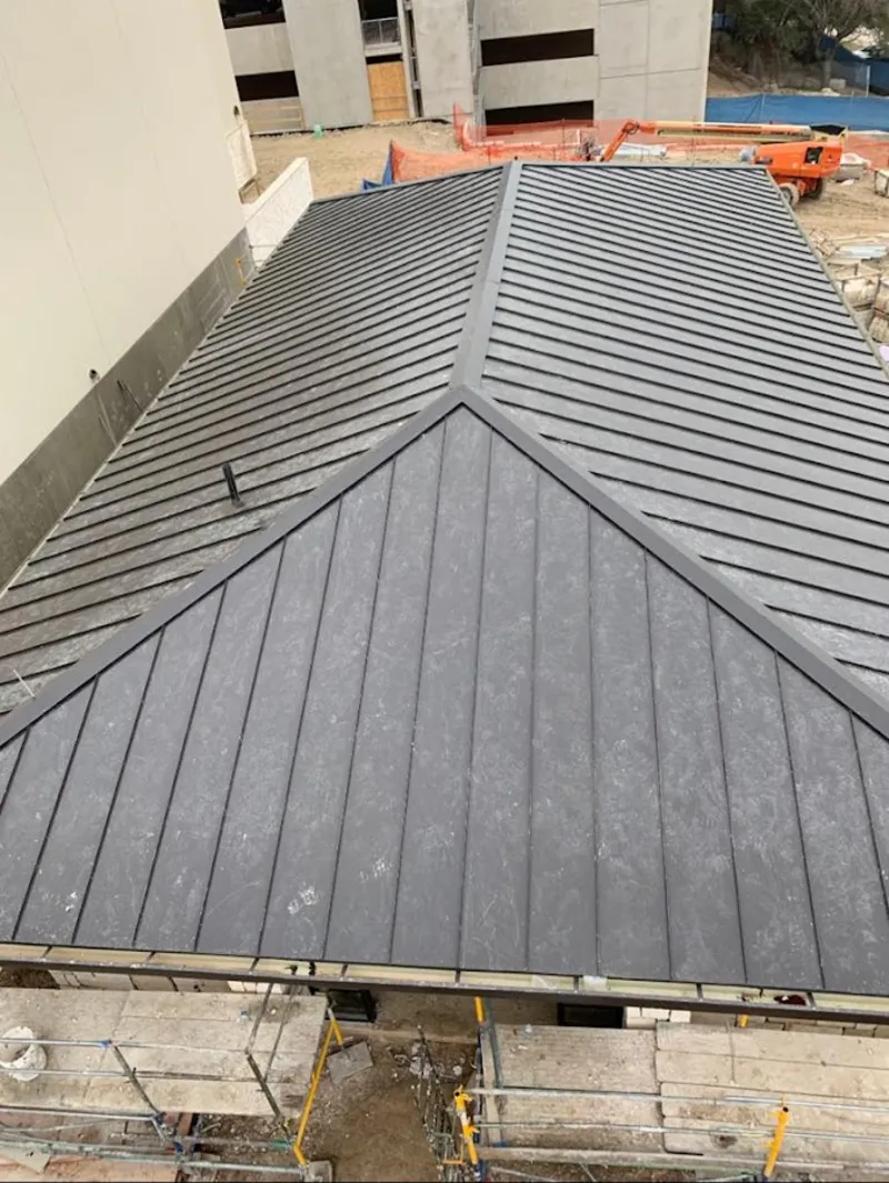 Commercial metal roof construction with crane equipment in Timberlane