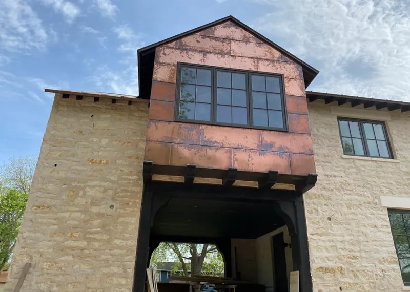 Copper metal panel facade on a stone building for Skylight Installation in Timberlane